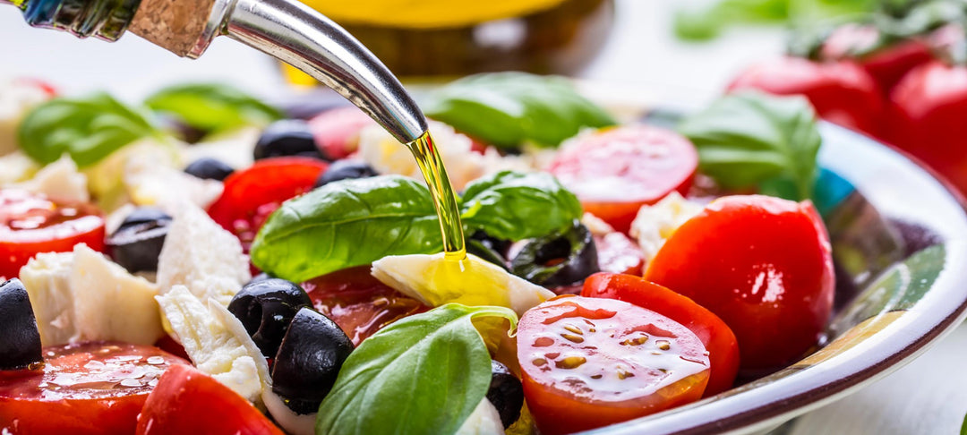 SUPPORT SUSTAINABLE LIVING WITH A MEDITERRANEAN DIET - Fresh salad with olive oil, tomatoes, and basil.