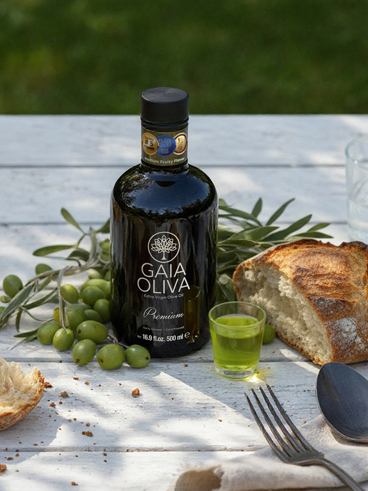 Bottle of Ayvalik Early Harvest Extra Virgin Olive Oil with olives and bread