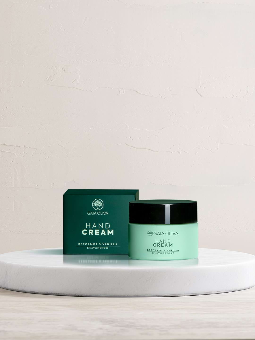 a jar of olive oil hand cream on marble surface.