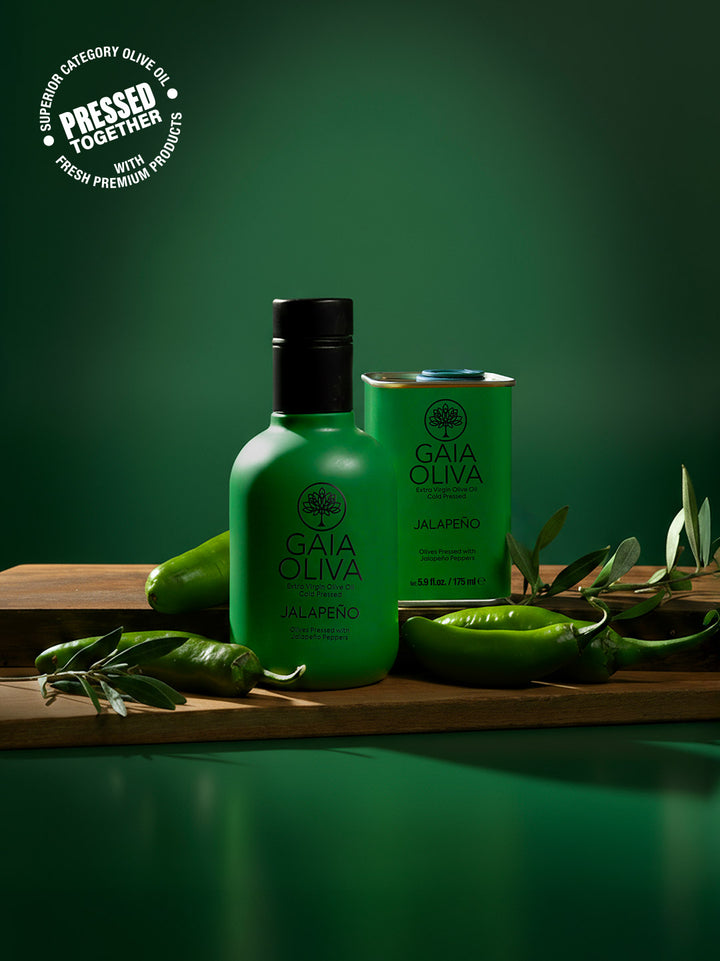Gaia Oliva bottle of Jalapeño Extra virgin olive oil and small tin of Jalapeño olive oil with green background