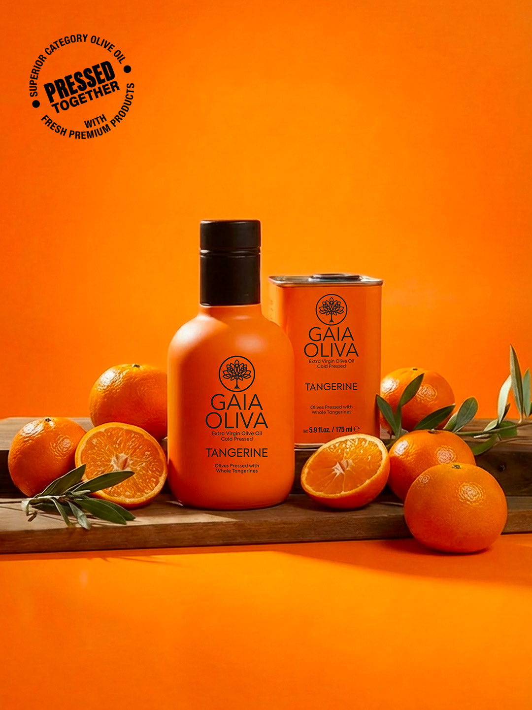 a bottle of tangerine extra virgin olive oil with fresh tangerine and small tin on a wooden surface