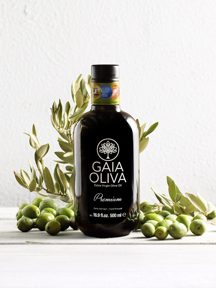 Premium Yamalak Early Harvest Extra Virgin Olive Oil 500 ml bottle with olives in background.